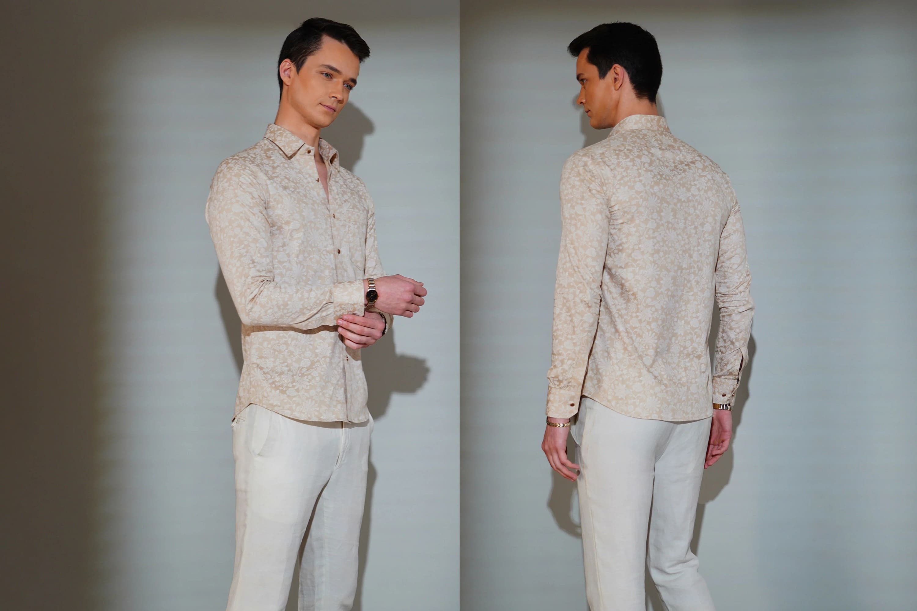Man wearing a light-colored patterned shirt and pants against a plain background