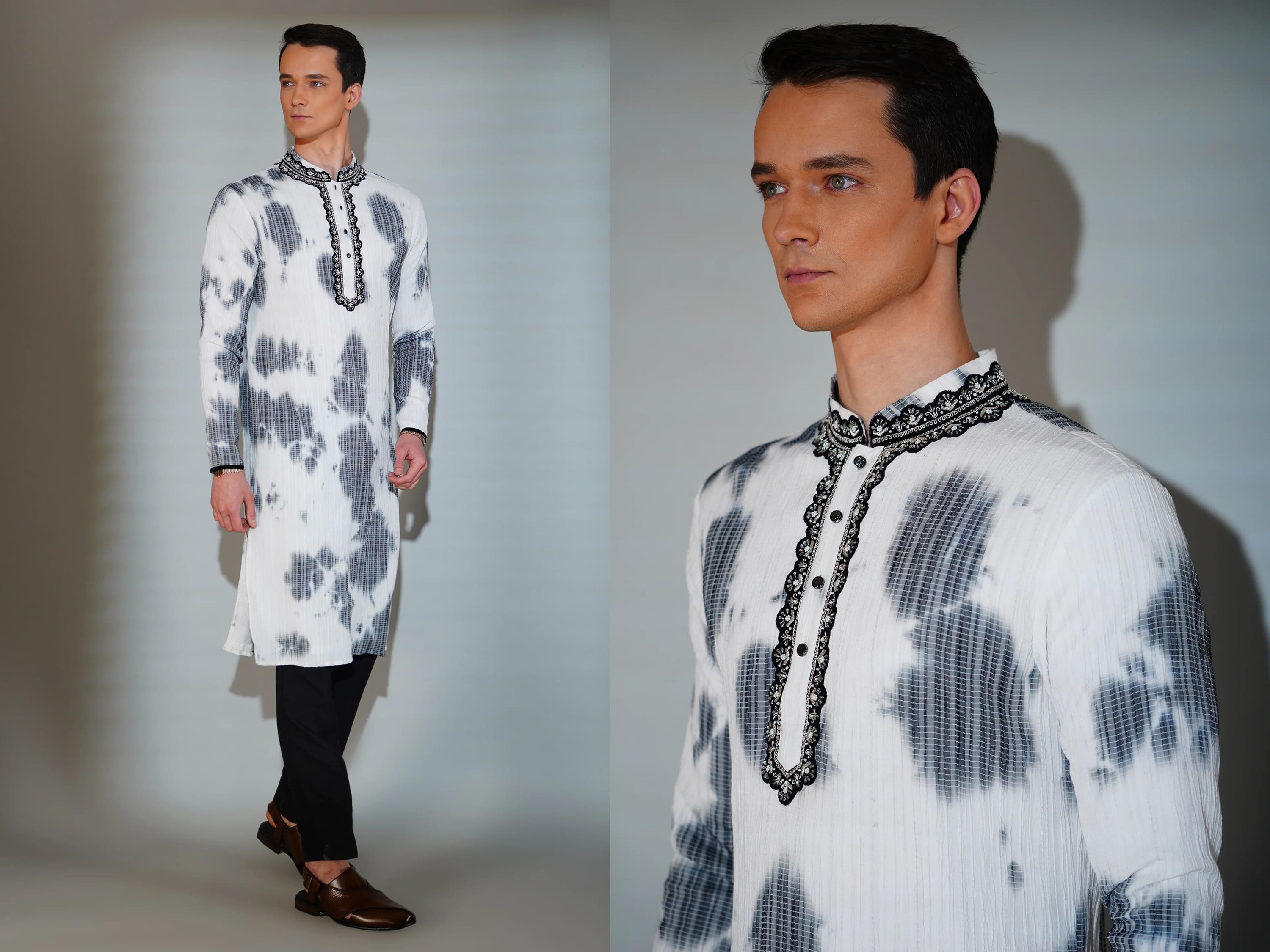 Man wearing a white and black patterned kurta with black pants against a plain background