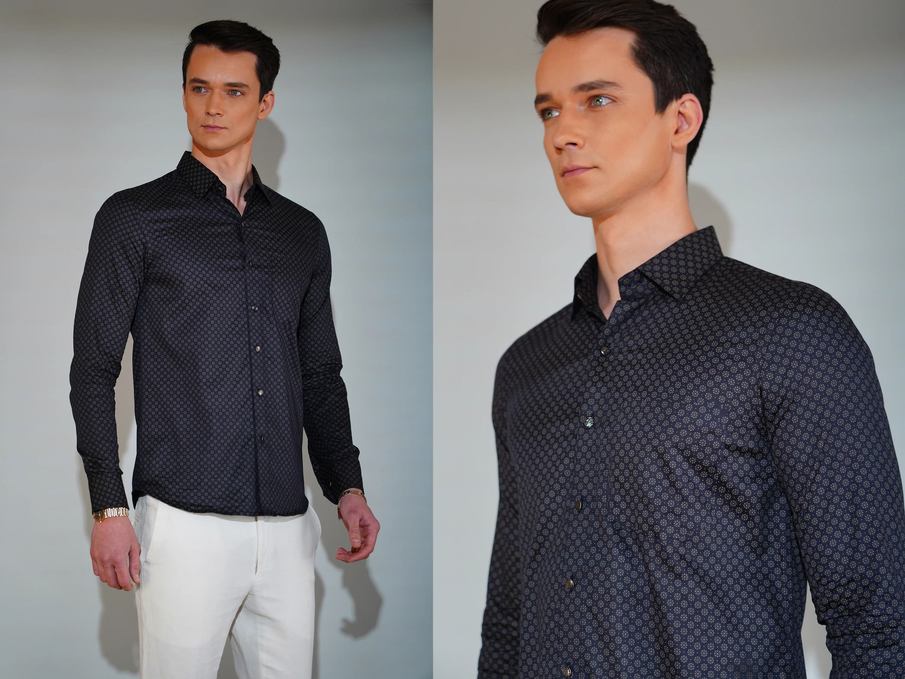 Man wearing a dark patterned shirt and white pants against a plain background