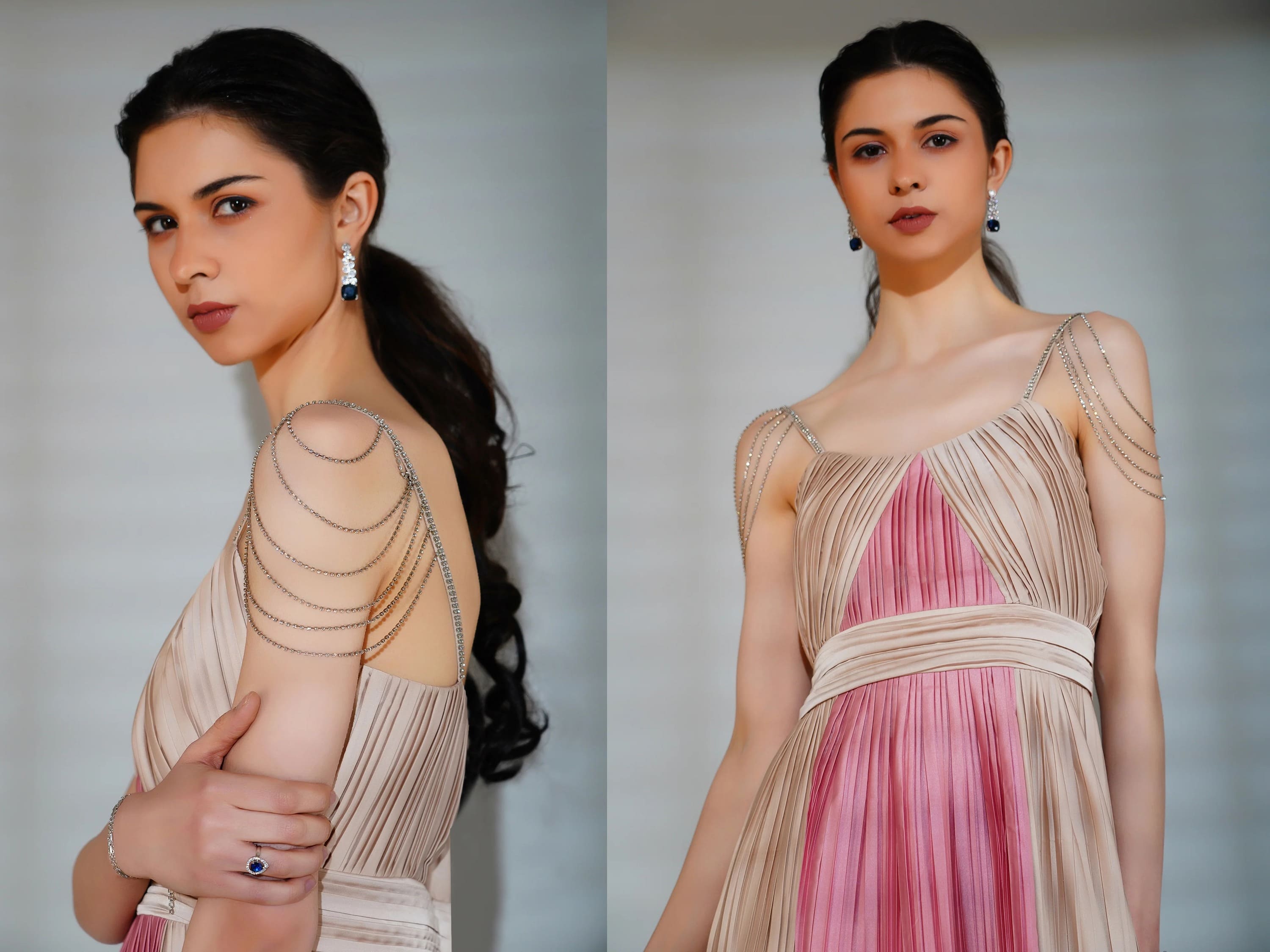 Woman wearing a pink and beige dress with intricate detailing on a plain background