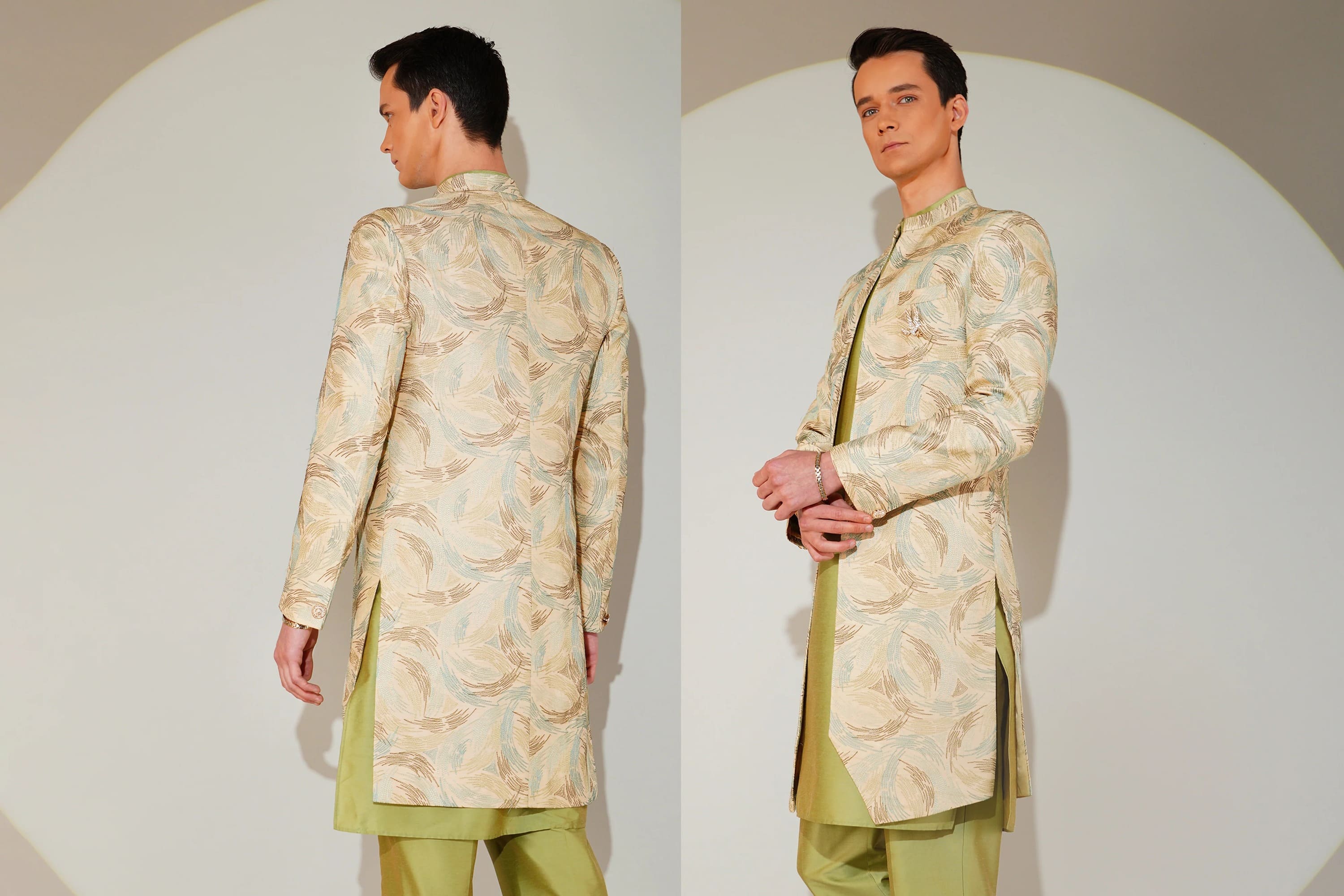 Man wearing a traditional light green sherwani with intricate patterns on a plain background